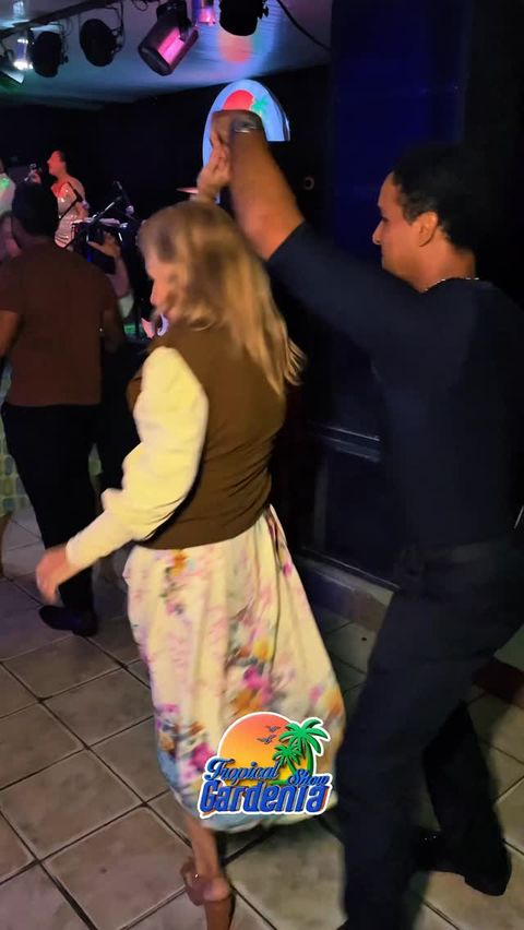 Casal dançando de mãos dadas na pista do Tropical Gardênia Show