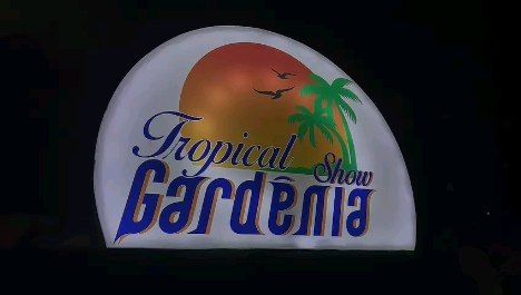Letreiro luminoso do Tropical Gardênia Show com sol, gaivotas e palmeira