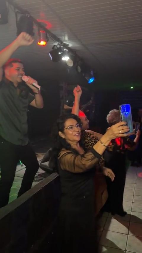 Cantor no palco e público de braços erguidos filmando o show
